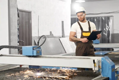 Man Working On CNC Laser Cutter And Cutting Metal Man Working On CNC Laser Cutter And Cutting Metal